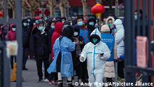 People wait for a throatswab at a COVID test site in a residential neighborhood of Beijing