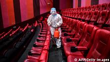 A staff member sprays disinfectant at a cinema as the city starts to reopen after a Covid-19 coronavirus outbreak in Shenyang, in China's northeastern Liaoning province on April 25, 2022. - China OUT (Photo by AFP) / China OUT (Photo by STR/AFP via Getty Images)