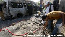 Pakistani investigators gather evidence at the site of explosion, in Karachi, Pakistan, Tuesday, April 26, 2022. The explosion ripped through a van inside a university campus in southern Pakistan on Tuesday, killing several people including Chinese nationals and their Pakistani driver, officials said. (AP Photo/Fareed Khan)