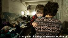 A woman holds a child in an improvised bomb shelter in Mariupol, Ukraine, Monday, March 7, 2022. (AP Photo/Mstyslav Chernov)