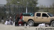 Taliban fighters load sacks of rice onto a military vehicle, given out as part of humanitarian aid sent by China to Afghanistan, at a distribution centre in Kabul, Afghanistan, April 7, 2022. REUTERS/Ali Khara