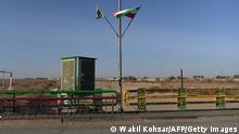 In this photo taken on February 18, 2022 a Taliban flag (L) and an Iranian flag wave at the zero point of Afghan-Iran border crossing bridge in Zaranj. (Photo by Wakil KOHSAR / AFP) (Photo by WAKIL KOHSAR/AFP via Getty Images)
