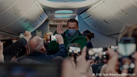 A still from the film in which Navalny is on an airplane greeting press.