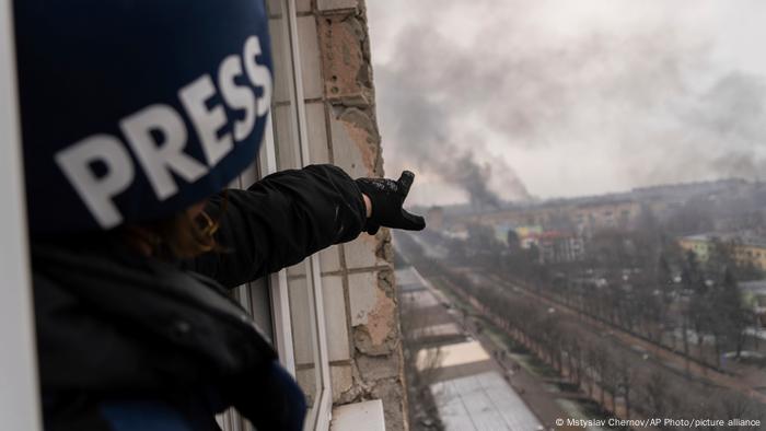 O fotojornalista Evgeniy Maloletka aponta para maternidade atingida por bombardeio em Mariupol