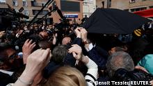 27.04.2022 *** French President Emmanuel Macron is protected with an umbrella after a projectile was sent during a walkabout at the Saint-Christophe market square in Cergy, Paris suburb, during his first trip after being re-elected president, France, April 27, 2022. REUTERS/Benoit Tessier/Pool