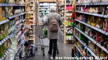 Eine Frau geht mit ihrem Einkaufswagen durch einen Supermarkt. (Zu dpa «Handel hofft auf Impulse im Ostergeschäft - trotz Pandemie und Krieg») +++ dpa-Bildfunk +++