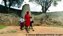 A tour guide leads school children past the conical tower at the Great Zimbabwe monument near Masvingo is seen on February 20, 2020. - Six of the large carvings were stolen from the ruins of Great Zimbabwe, an imposing stone complex built between the 11th and 13th centuries and attributed to pre-colonial King Munhumutapa.
The palatial enclosures are now a UNESCO world heritage site situated in the southeast of Zimbabwe, some 25 kilometres (16 miles) from the present day city of Masvingo. Almost all of the prized green-grey soapstone birds that were looted have now been returned to the country. (Photo by Jekesai NJIKIZANA / AFP) (Photo by JEKESAI NJIKIZANA/AFP via Getty Images)