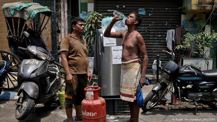 A man distributes drinking water to needy passersby in Kolkata