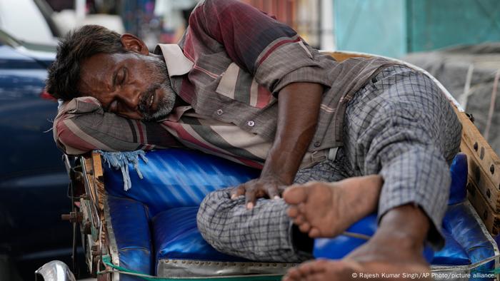 A man sleeps on his rickshaw in Lucknow