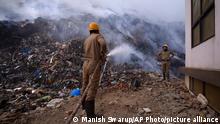 Fire officials try to douse a fire at the Bhalswa landfill in New Delhi, India, Wednesday, April 27, 2022. The landfill that covers an area bigger than 50 football fields, with a pile taller than a 17-story building caught fire on Tuesday evening, turning into a smoldering heap that blazed well into the night. India's capital, which like the rest of South Asia is in the midst of a record-shattering heat wave, was left enveloped in thick acrid smoke. (AP Photo/Manish Swarup)