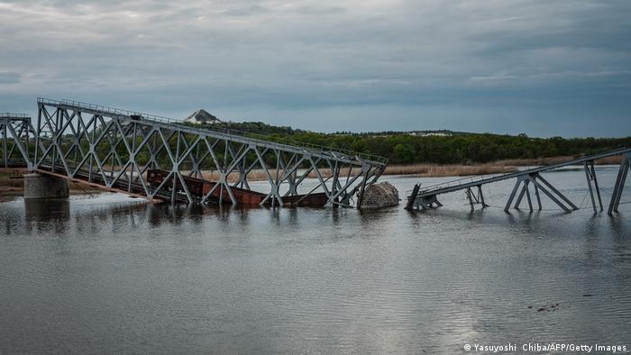 Des sections d'un pont ferroviaire détruit se sont effondrées dans une rivière