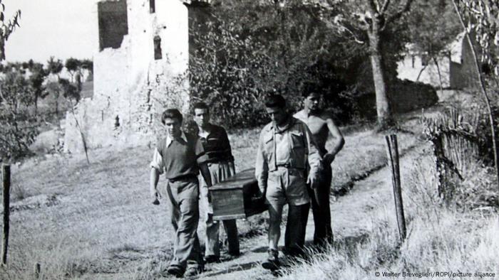 Italienische Partisanen tragen 1945 einen Sarg mit den sterblichen Überresten eines Massaker-Opfers vob Marzabotto 