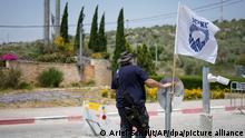 An Israeli security guard secures the entrance to the Jewish settlement of Ariel in the West Bank near the Palestinian city of Nablus, Saturday, April 30, 2022. The Israeli military says it is searching for a pair of Palestinian attackers who shot and killed a security guard at the entrance of a Jewish settlement in the occupied West Bank. The shooting took place late Friday at the entrance to Ariel, a major settlement in the northern West Bank. (AP Photo/Ariel Schalit)