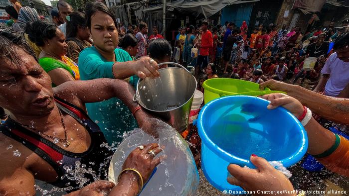 People are seen filling water from a municipal tanker