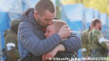 Azovstal steel plant employee Maxim, last name withheld, evacuated from Mariupol, hugs his son Matvey, who had earlier left the city with his relatives, as they meet at a temporary accommodation centre during Ukraine-Russia conflict in the village of Bezimenne in the Donetsk Region, Ukraine May 1, 2022. REUTERS/Alexander Ermochenko