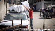 A Palestinian man loads bags of food rations atop a car, outside an aid distribution center run by the United Nations Relief and Works Agency (UNRWA) at the al-Shati camp for Palestinian refugees in Gaza City on October 2, 2021. - UNRWA is seeking to mobilize 800 million USD in funds during a donors conference in Brussels in mid-November, the organisation's commissioner-general said. (Photo by MAHMUD HAMS / AFP) (Photo by MAHMUD HAMS/AFP via Getty Images)