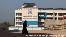 A Palestinian woman walks past the shuttered headquarters of the United Nations Relief and Works Agency for Refugees (UNRWA) in Gaza City during a general strike of employees in UNRWA institutions in the Palestinian strip, on November 29, 2021. (Photo by Mohammed ABED / AFP) (Photo by MOHAMMED ABED/AFP via Getty Images)