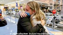 Families embrace after a flight from Los Angeles arrived at Auckland International Airport as New Zealand's border opened for visa-waiver countries Monday, May 2, 2022. New Zealand welcomed tourists from the U.S., Canada, Britain, Japan and more than 50 other countries for the first time in more than two years as it dropped most of its remaining pandemic border restrictions. (Jed Bradley/New Zealand Herald via AP)