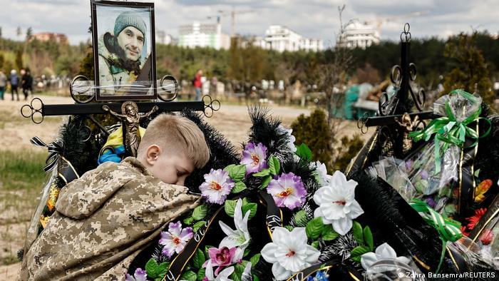 Момче тъгува на гроба на баща си в Ирпин