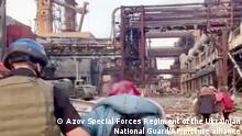 This frame taken from an undated video provided Sunday, May 1, 2022 by the Azov Special Forces Regiment of the Ukrainian National Guard shows people walking over debris at the Azovstal steel plant, in Mariupol, eastern Ukraine. As many as 100,000 people may still be in Mariupol, including an estimated 2,000 Ukrainian fighters beneath the sprawling, Soviet-era steel plant â€” the only part of the city not occupied by the Russians. (Azov Special Forces Regiment of the Ukrainian National Guard via AP)