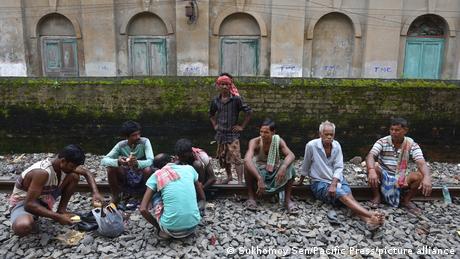 Men sit on train tracks
