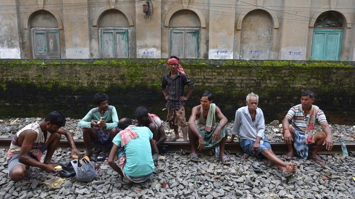 Men sit on train tracks