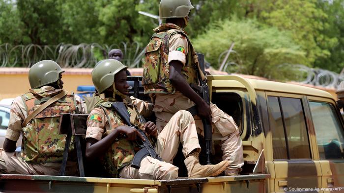 Mali soldiers sit in the back of a military pickup truck