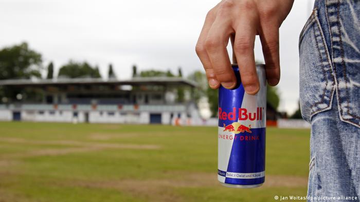 A man stands with a can of Red Bull in the Stadion am Bad in Markranstaedt near Leipzig, Germany,