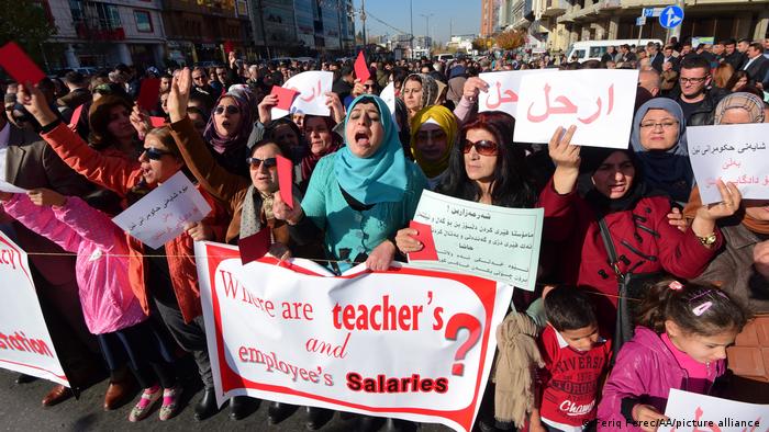 Thousands of public servants hold banners and shout slogans as they gather in front of Provincial Directorate of Education building during a demonstration to protest non-payment of salaries .