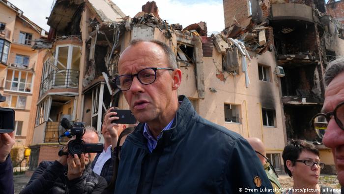Der CDU-Chef Friedrich Merz steht in der ukrainischen Stadt Irpin vor zerstörten Wohnhäusern