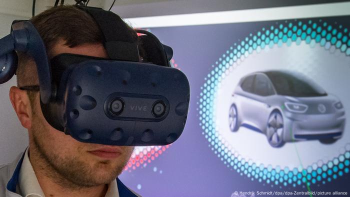 A man wears a virtual reality headset to test a new Volkwagen car