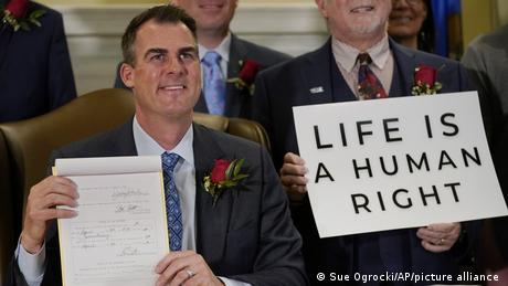 Kevin Stitt zeigt das von ihm unterzeichnete Gesetz zum Verbot der Abtreibung 