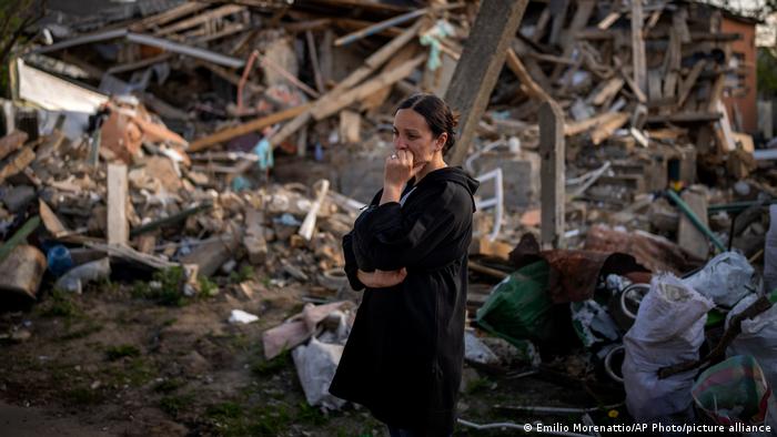 Женщина перед руинами разрушенного дома в Ирпене