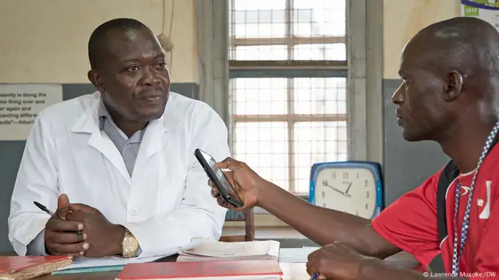 Man interviewing doctor seated at desk