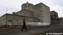 This photo taken on April 5, 2022 shows a security guard walking in front of the main gate of the Bataan Nuclear Power Plant in the town of Morong in Bataan province, north of Manila. - The nuclear power plant built in the disaster-prone Philippines during Ferdinand Marcos's regime, but never switched on due to safety fears and corruption, could be revived if his son wins the May 9 presidential poll. (Photo by Ted ALJIBE / AFP) / TO GO WITH Philippines-politics-nuclear-energy,FOCUS by Allison Jackson
