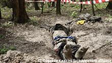 BUCHA, UKRAINE - MAY 04: (EDITORS NOTE: Image depicts death) Police officers inspect the dead body of a man after revealing it from Russian positions in Bucha, located 15 kilometers from Kyiv, Ukraine on May 04, 2022. Dogukan Keskinkilic / Anadolu Agency