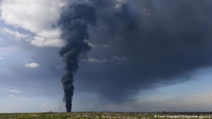 Gray smoke rises over an oil depot hit by fire in Ukraine