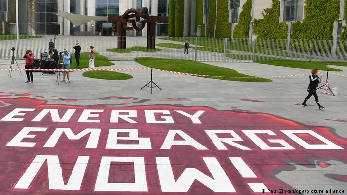 Auf dem Boden vor dem Kanzleramt steht in großen Buchstaben Energy Embargo Now!