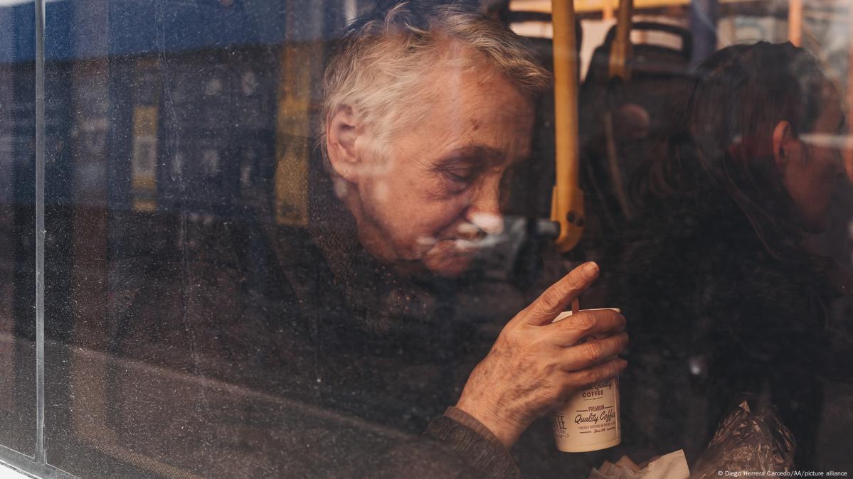 Ein alter Mann sitzt im Evakuierungs-Bus und hält einen Becher mit einem Getränk in der Hand. Ukraine, 3. Mai, Diego Herrera Carcedo / Anadolu Agency