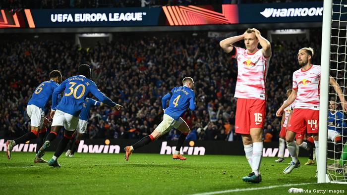 John Lundstram celebrates his winner as Leipzig players hold their heads in their hands in the UEFA Europa League game between Rangers and Leipzig