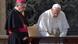 Cardinal Angelo Becciu and Pope Francis stand side by side as the pope signs a document Cardinal Angelo Becciu and Pope Francis stand side by side as the pope signs a document