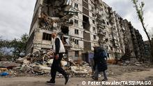DONETSK REGION, UKRAINE - MAY 5, 2022: Residents walk past an apartment building damaged by shelling in the embattled city of Mariupol. With tension escalating in Donbass in February, the Russian Armed Forces launched a special military operation in Ukraine in response to appeals for help from the Donetsk and Lugansk People s Republics. Peter Kovalev/TASS PUBLICATIONxINxGERxAUTxONLY TS12FC4B 