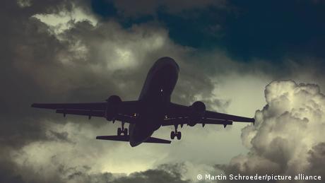 A plane flying in the sky on a cloudy day