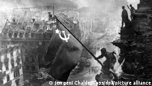 Der sowjetische Soldat Militon Kantarija aus Georgien hisst am 2. Mai 1945 die sowjetische Flagge auf dem Berliner Reichstag. Deutschland hatte den Zweiten Weltkrieg verloren. (zu dpa Eine Woche im Mai - vor 75 Jahren endete der Zweite Weltkrieg - nur s/w) +++ dpa-Bildfunk +++