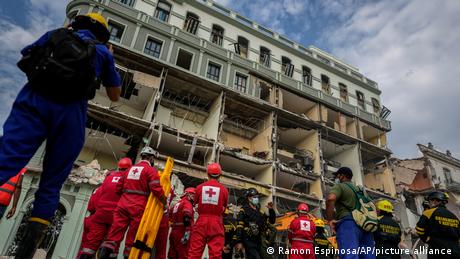 Red Cross and rescue teams wait to enter the site of a deadly explosion that destroyed the five-star Hotel Saratoga, in Havana, Cuba
