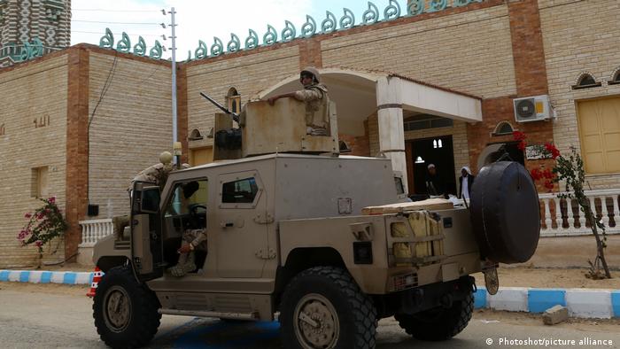 Members of security forces patrol around al-Rawda mosque, in Sinai