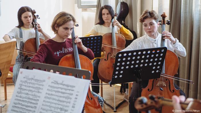 Four musicians playing cello.