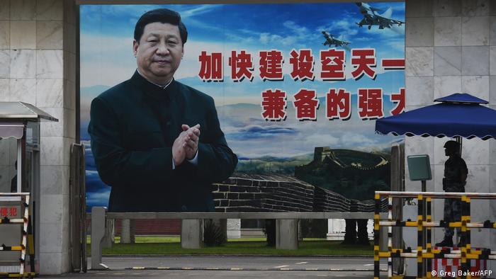 Soldier in front of portrait of Xi Jinping at entrance to military base in Guilin, in China