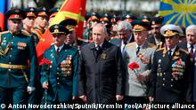 Russian President Vladimir Putin, centre, attends a wreath-laying ceremony at the Tomb of the Unknown Soldier after the military parade marking the 77th anniversary of the end of World War II, in Moscow, Russia, Monday, May 9, 2022. (Anton Novoderezhkin, Sputnik, Kremlin Pool Photo via AP)