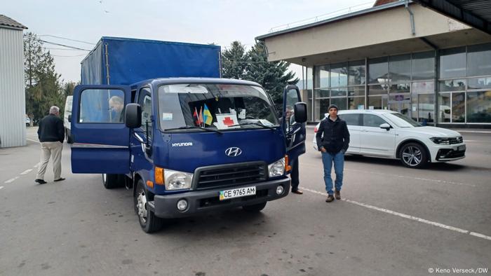 Blue truck in a parking lot, two men